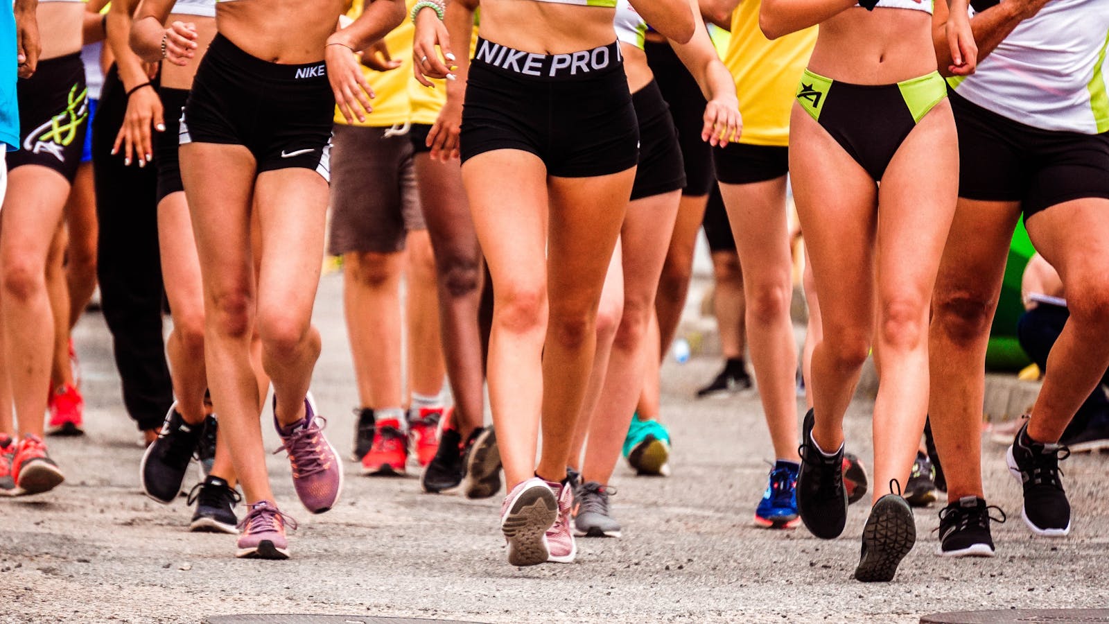 A group of runners participating in an outdoor street marathon wearing athletic gear.