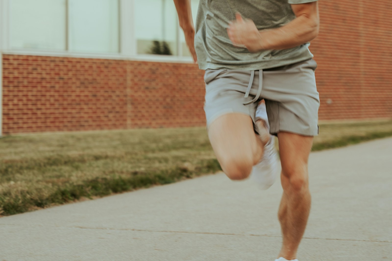 a man running down a sidewalk in front of a building