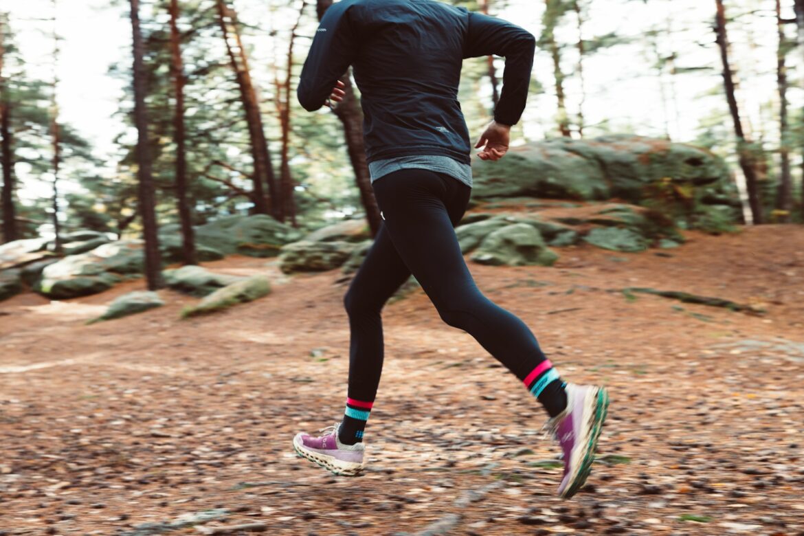 a man running in the woods on a trail