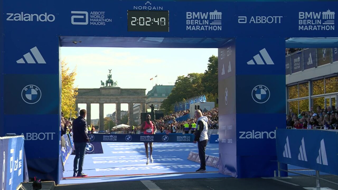 Guye Adola loopt als winnaar naar de finish bij de Brandenburger Tor in Berlijn