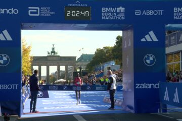 Guye Adola loopt als winnaar naar de finish bij de Brandenburger Tor in Berlijn