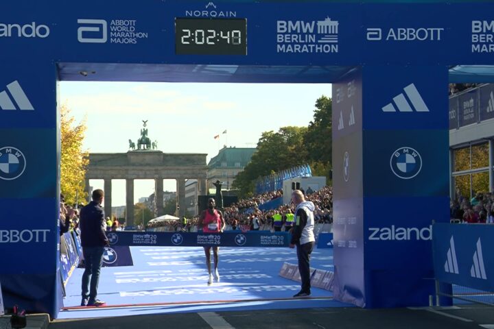 Guye Adola loopt als winnaar naar de finish bij de Brandenburger Tor in Berlijn