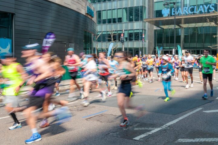 Groep hardlopers in een dicht peloton tijdens een stadsloop op straat