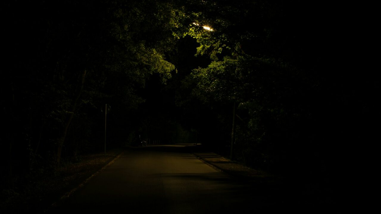 Hardloper met een hoofdlamp loopt 's nachts door een verlichte straat