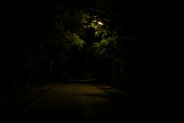 Hardloper met een hoofdlamp loopt 's nachts door een verlichte straat