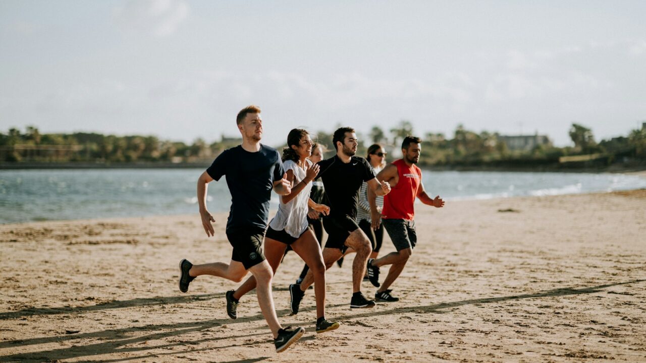 Hardlopers op het natte zand langs de vloedlijn tijdens een strandloop