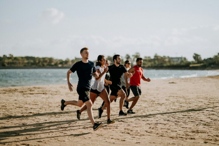Hardlopers op het natte zand langs de vloedlijn tijdens een strandloop