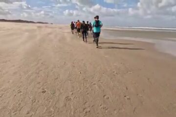 Groep lopers op het strand tijdens de Kustmarathon Zeeland