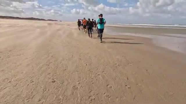 Groep lopers op het strand tijdens de Kustmarathon Zeeland