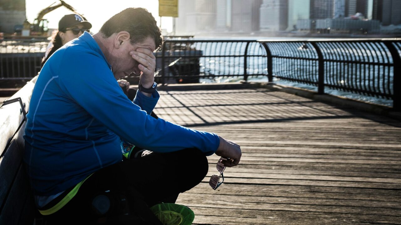 Hardloper zit na een lange duurloop uit te rusten op een bankje