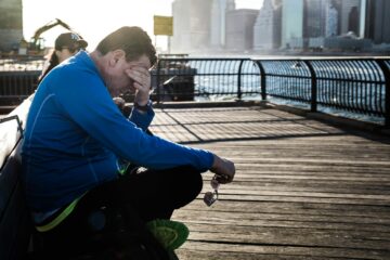 Hardloper zit na een lange duurloop uit te rusten op een bankje