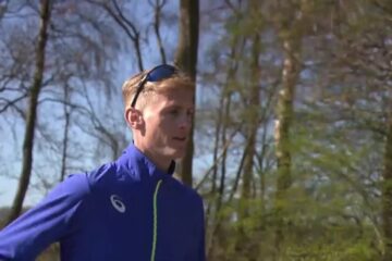 Marathonloper Tom Hendrikse in een blauw trainingsjack tijdens een training in het bos