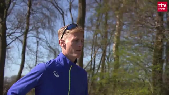 Marathonloper Tom Hendrikse in een blauw trainingsjack tijdens een training in het bos