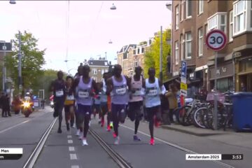 Toplopers op een afgesloten straat met tramrails tijdens de marathon van Amsterdam