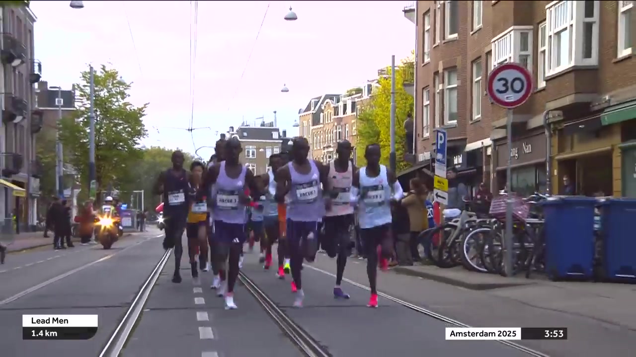 Toplopers op een afgesloten straat met tramrails tijdens de marathon van Amsterdam
