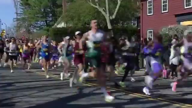 Lopers in de Boston Marathon van 2026 in een woonwijk langs het parcours