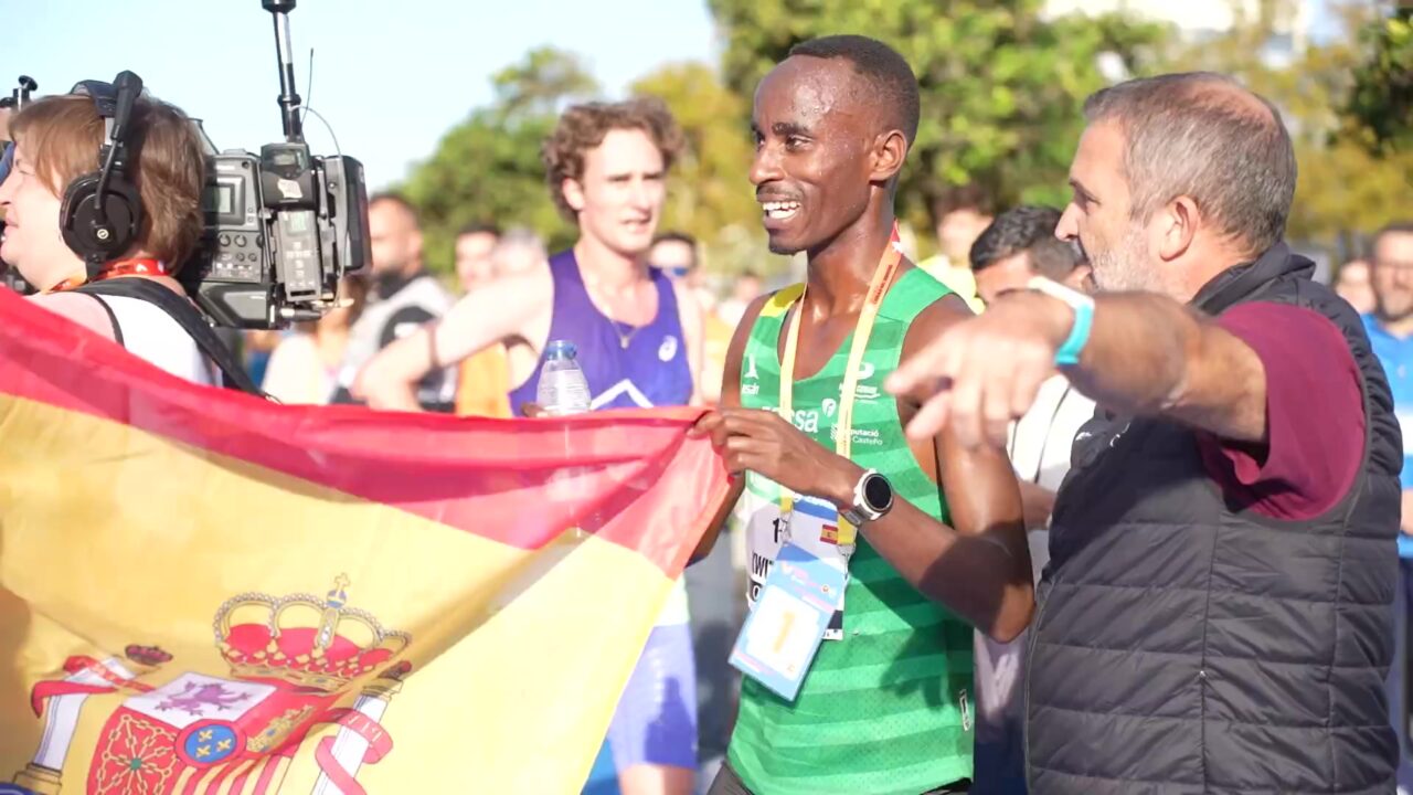 Rodrigue Kwizera met de Spaanse vlag na zijn zege in de halve marathon van Valencia