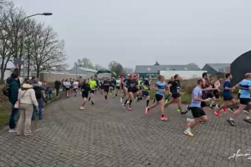 Lopers bij de start van de Halve van Haren op een klinkerweg in Haren