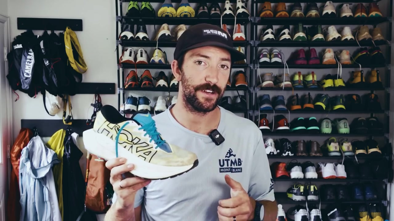 De Hoka Rocket X Trail in geel en wit, van opzij in de hand gehouden