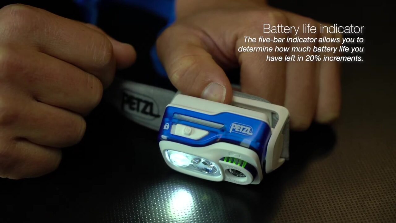 Een hardloophoofdlamp van Petzl met brandend licht en accu-indicator