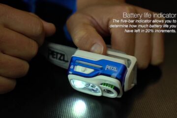 Een hardloophoofdlamp van Petzl met brandend licht en accu-indicator