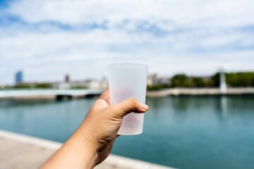 Bekers water op een tafel bij een drankpost langs een hardloopparcours