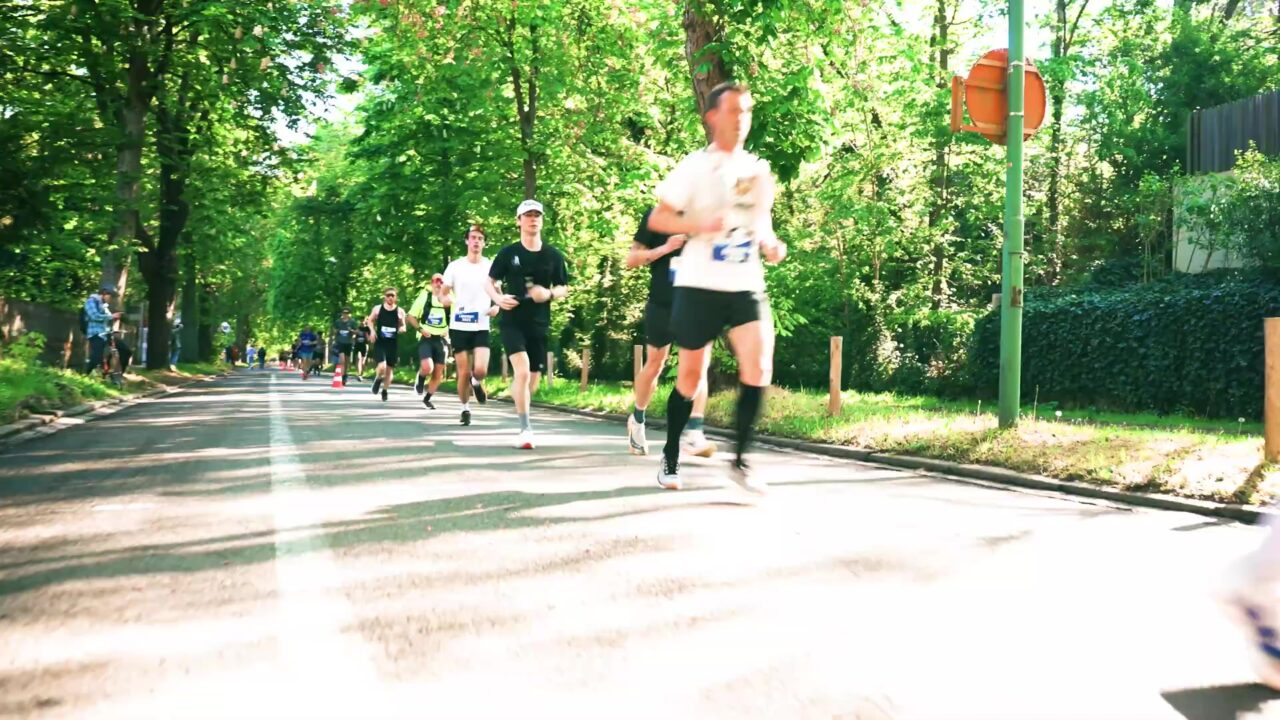 Lopers in de Leuven Marathon 2026 op een groene laan in Leuven