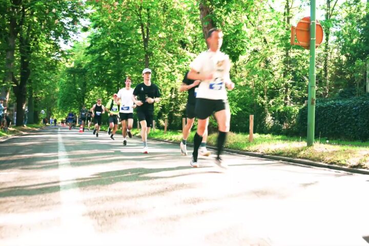 Lopers in de Leuven Marathon 2026 op een groene laan in Leuven