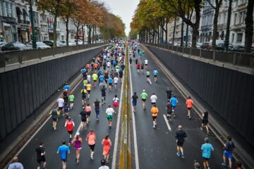 Hardloper in de stad langs een drukke weg