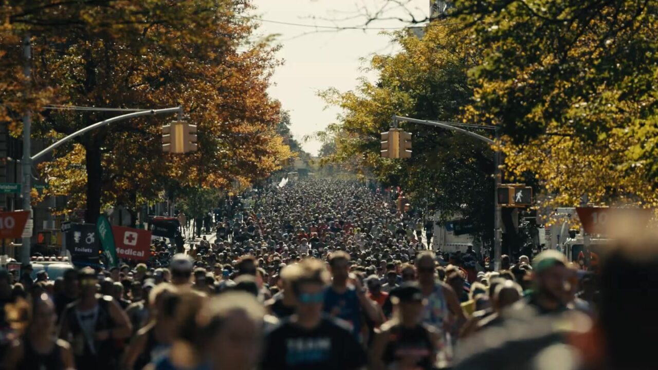 Duizenden lopers in een straat met herfstbomen tijdens de marathon van New York