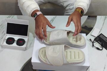 De Nike Air Zoom Hyperslide herstelslippers naast de twee losse pods in hun doos