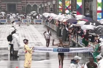 Ruti Aga komt in de regen als winnares over de finish van de marathon van Tokio in 2019