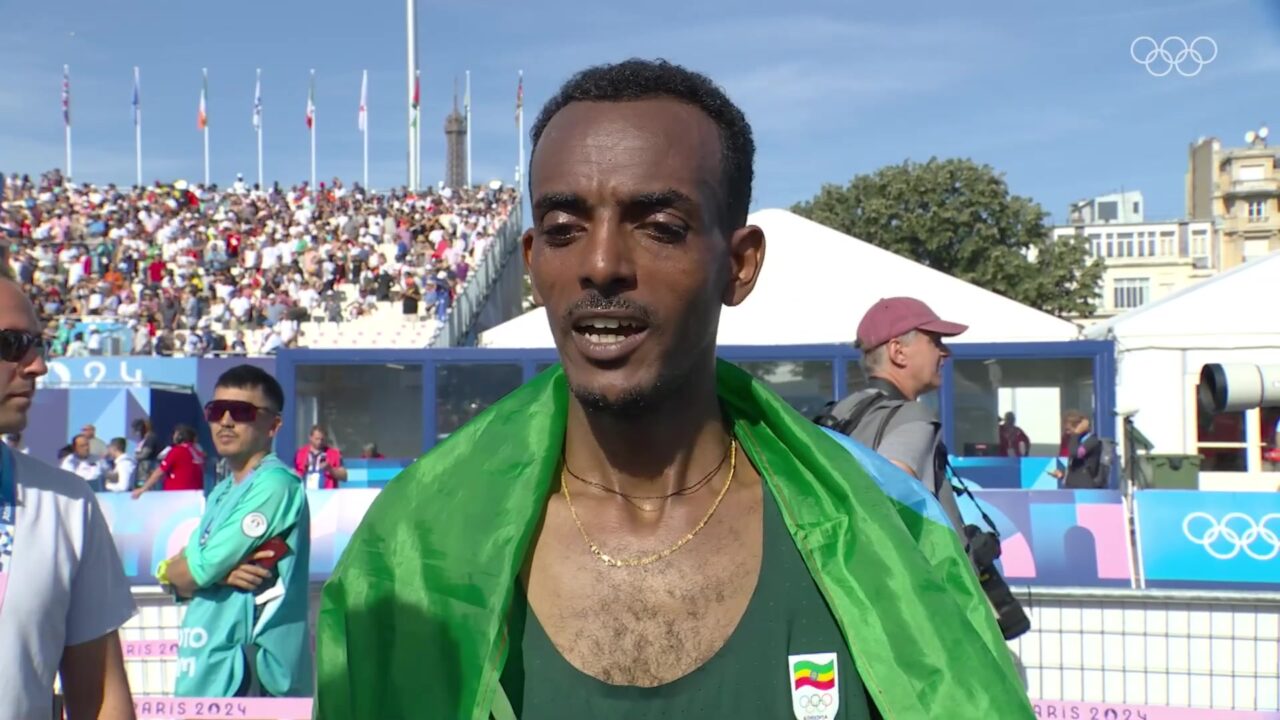 Tamirat Tola met de Ethiopische vlag na zijn olympische marathonzege in Parijs