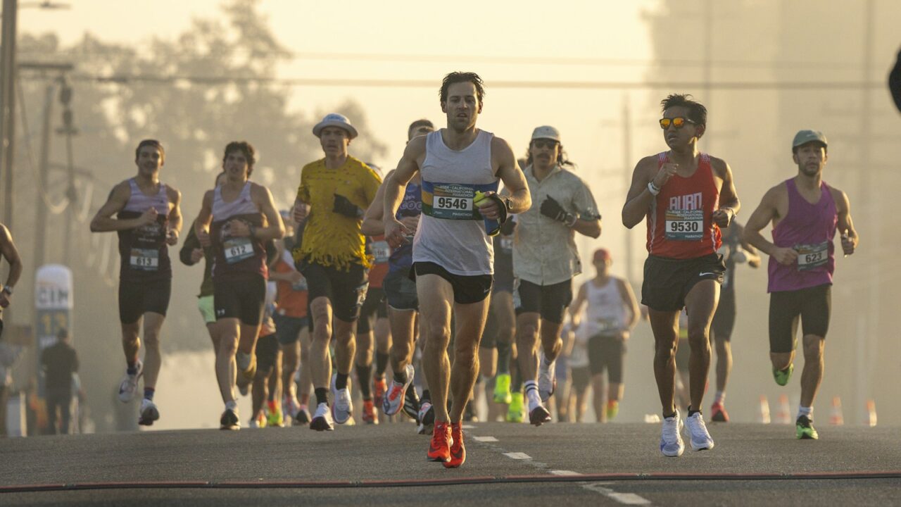 Marathonloper neemt een energiegel bij een drankpost