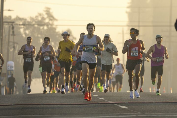 Marathonloper neemt een energiegel bij een drankpost