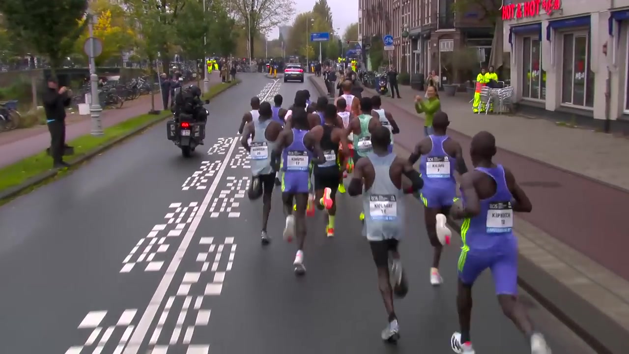 Kopgroep op nat asfalt tijdens de marathon van Amsterdam
