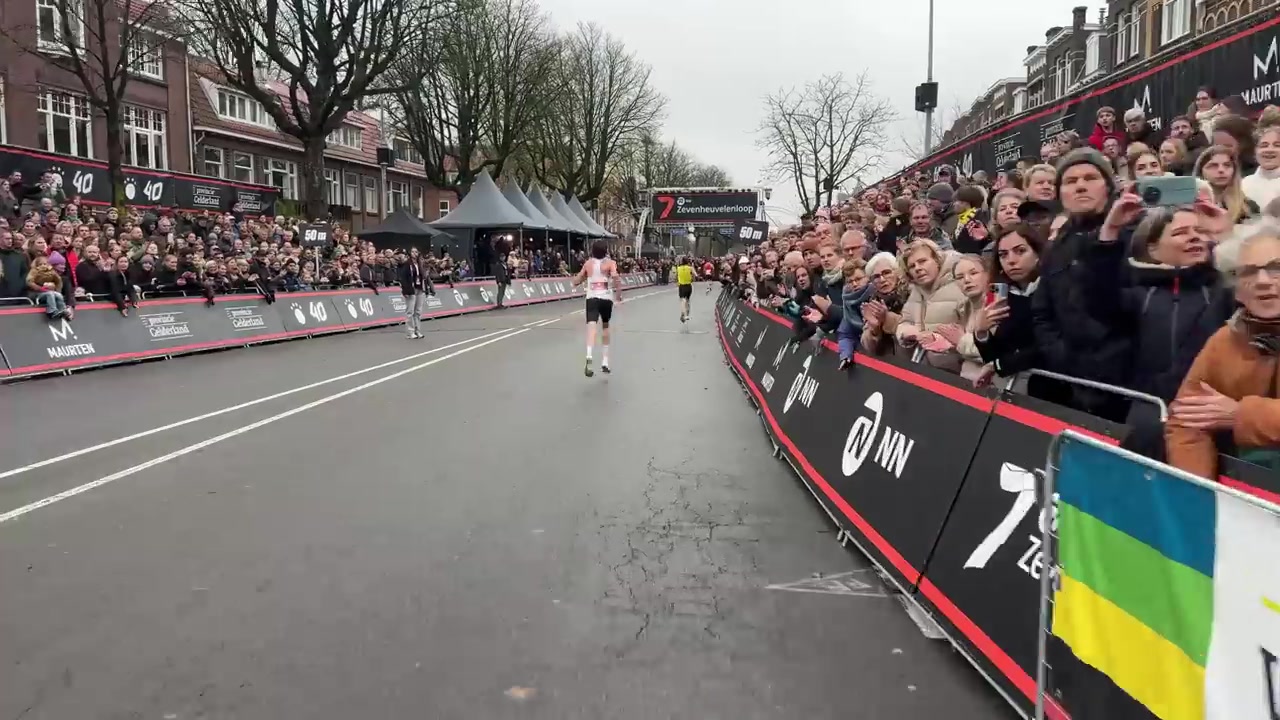 Lopers op de finishstraat van de Zevenheuvelenloop aan de Groesbeekseweg in Nijmegen, met publiek langs de hekken